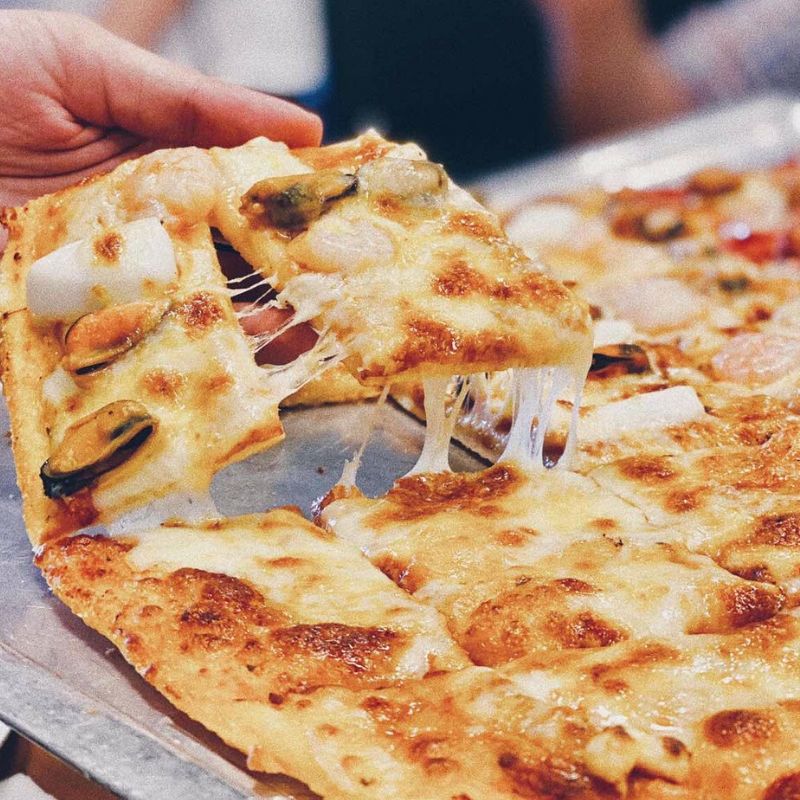 Phần đế của những chiếc pizza đế có độ dày vừa đủ để bạn không bị ngấy kết hợp với lớp giữa dai, mặt dưới giòn, cháy cạnh và được phủ đầy toppings trên mặt bánh